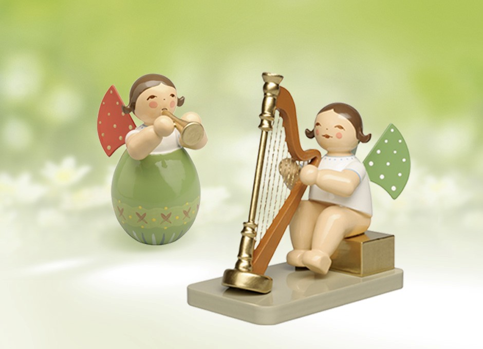 Zwei handgemachte Holzengel mit grünen Flügeln aus der Manufaktur Wendt & Kühn im Erzgebirge, einer steht in einem Osterei und spielt Trompete, der andere sitzt an einer Harfe
